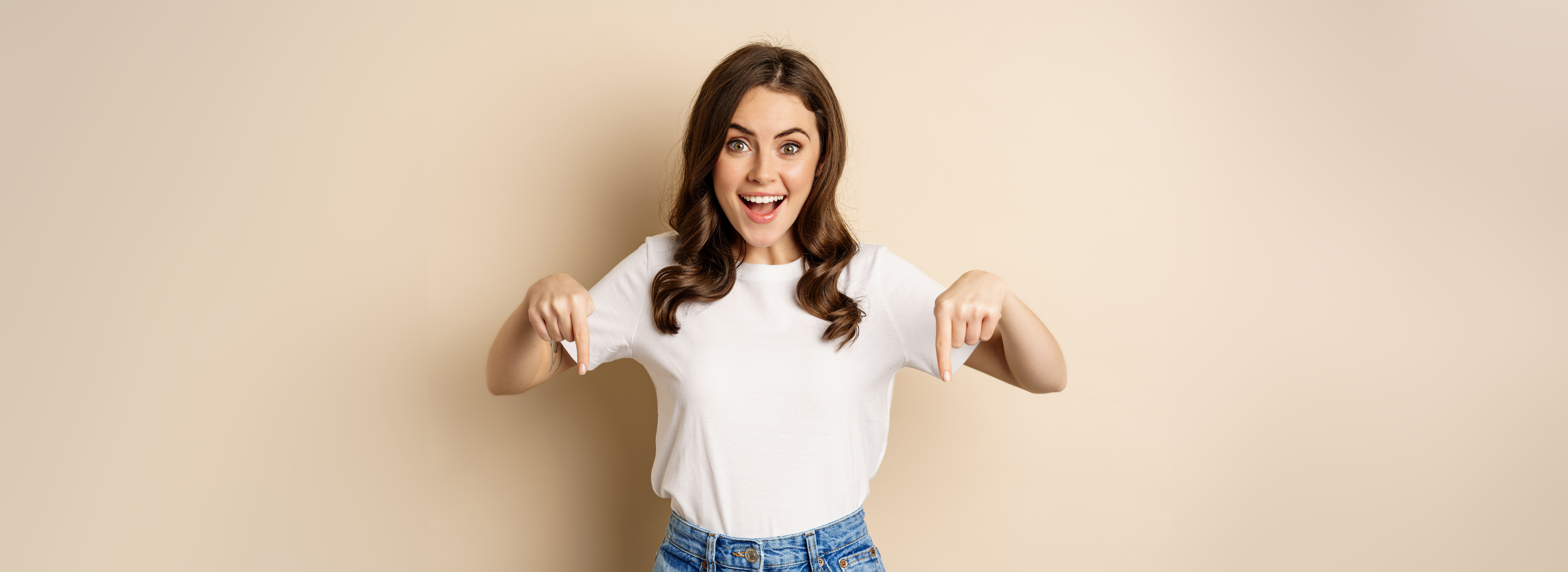 Smiling Happy Girl Pointing Fingers down and Showing Banner, Company Logo below, Click Link, Standing over Beige Background